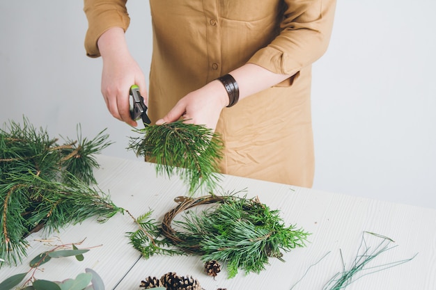 Foto decorador de floristería haciendo corona de navidad