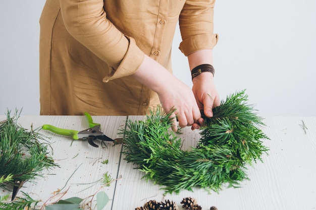 Decorador de floristería haciendo corona de Navidad