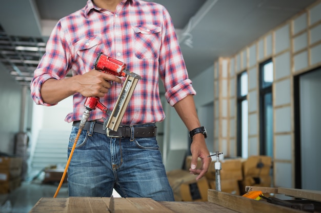 Decorador trabajando en diseño e inspección de madera contrachapada en el sitio de construcción; decorador comprobando material para interior