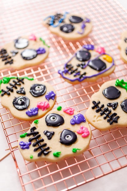 Decorando biscoitos de açúcar com glacê real para o feriado de Dia de los Muertos.