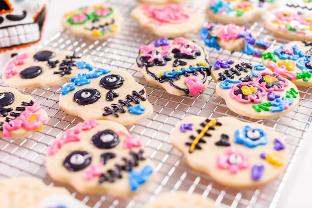 Decorando biscoitos de açúcar com glacê real para o feriado de Dia de los Muertos.