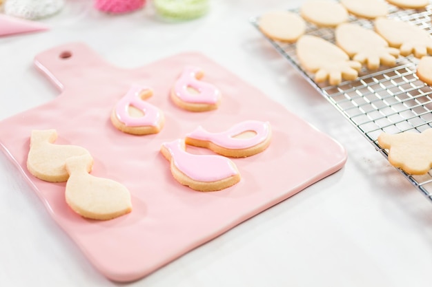 Decorando biscoitos de açúcar de Páscoa com glacê rotativo.