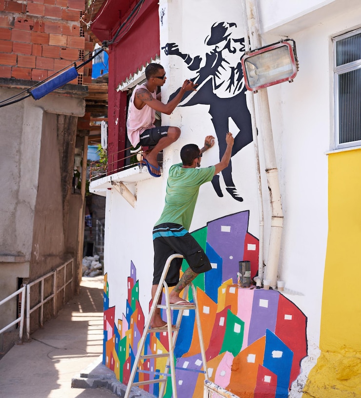Foto decorando sua cidade foto de dois jovens grafiteiros pintando um desenho em uma parede
