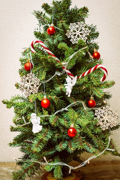 Foto decorar a árvore de natal com bolas, flocos de neve, bastões de doces, guirlanda de luzes, decoração festiva. natal, decorações de ano novo. conceito de férias de inverno com espaço de cópia.