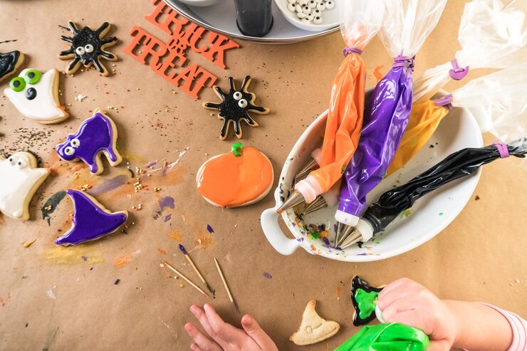 Foto decorar biscoitos de açúcar de halloween com crosta de gelo real colorida.