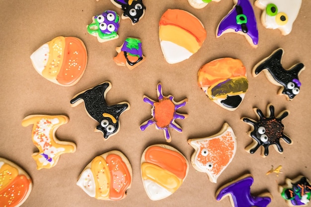 Decorar biscoitos de açúcar de Halloween com crosta de gelo real colorida.