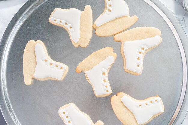 Decorar biscoitos de açúcar em forma de patins com glacê real.