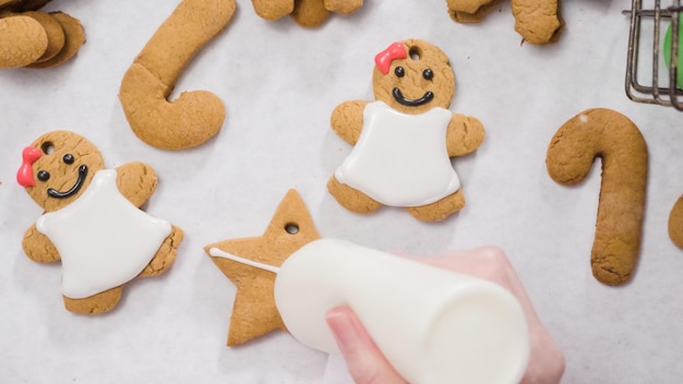 Decorar biscoitos de gengibre com glacê real para o Natal.