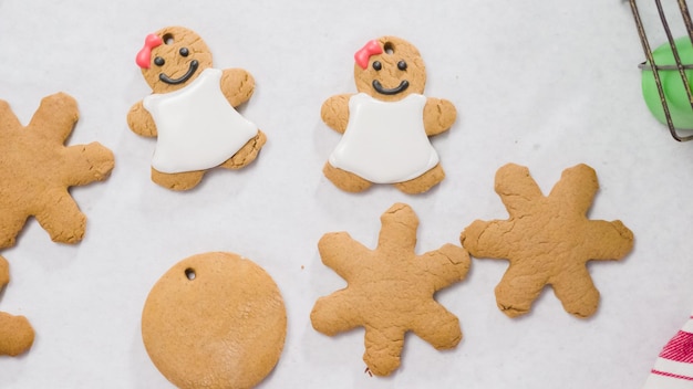 Decorar biscoitos de gengibre com glacê real para o Natal.