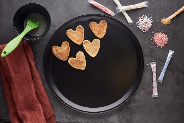 Decorar galletas de azúcar con glaseado y chispas para el Día de San Valentín