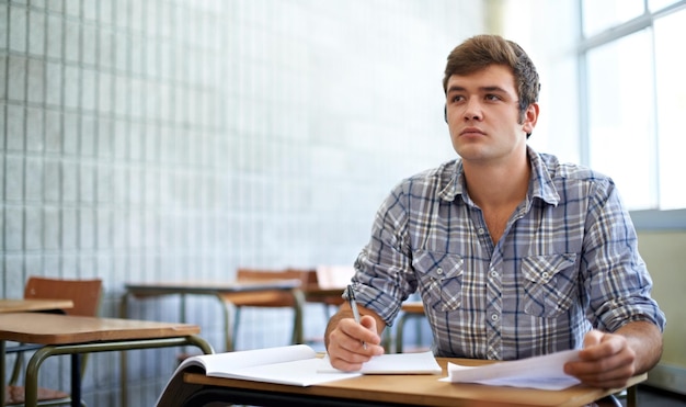 Dedicado a su educación Foto de un joven estudiante universitario que estudia en clase