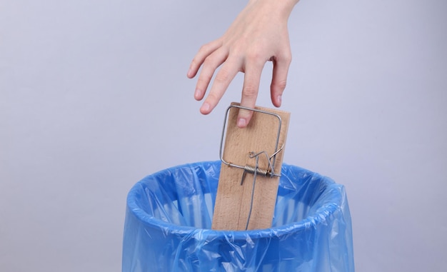 Dedo atrapado en una ratonera en el fondo del bote de basura