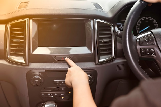 Dedo da mulher que pressiona o botão da emergência no painel do carro. Conceito de transporte.