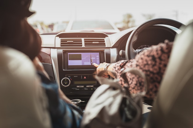 Dedo de mulher tocando uma tela de navegação por toque no painel do carro
