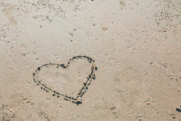 Dedo desenhado coração símbolo de amor no conceito de verão mar praia areia férias