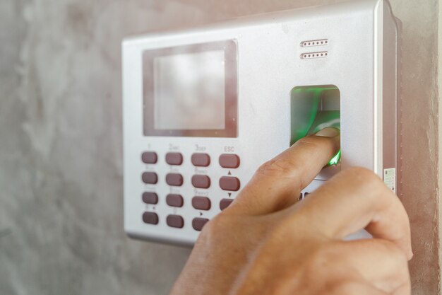 Foto el dedo del hombre sobre el escaneo de huellas digitales para ingresar al sistema de seguridad