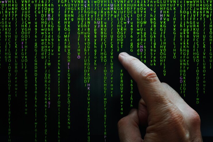 Foto dedo índice apuntando al código binario de la pantalla digital