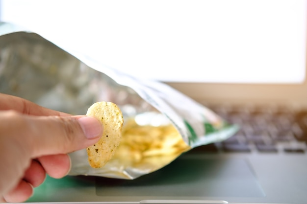 dedo de la mano con papas fritas (vacío) en el fondo del cuaderno