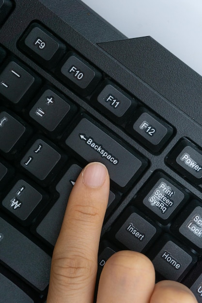 El dedo de una mujer sosteniendo un teclado de computadora