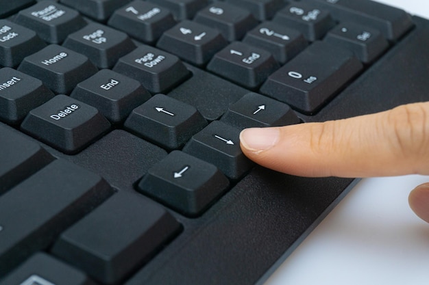 El dedo de una mujer sosteniendo un teclado de computadora