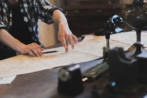 El dedo de una persona señalando el mapa antiguo para ir al destino