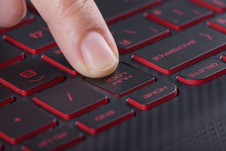 Foto dedo presionando el botón num lock en el teclado de la computadora portátil