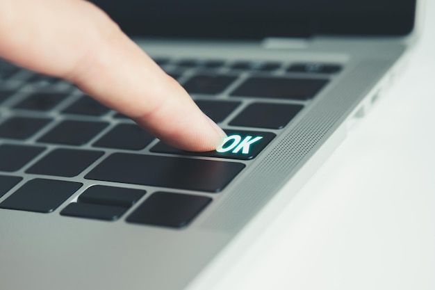 Foto dedo presionando el botón ok en el concepto de decisión del teclado