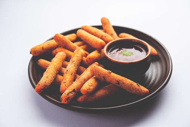 Dedos crocantes de Rava Aloo ou palitos fritos de sêmola de batata servidos com ketchup