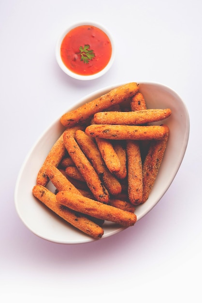 Dedos crocantes de Rava Aloo ou palitos fritos de sêmola de batata servidos com ketchup