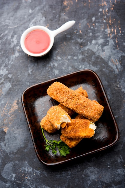 Dedos de Kurkuri paneer ou pakora, petiscos de pakoda também conhecidos como Barras de Queijo Cottage Crocante, servidos com ketchup de tomate como entrada. foco seletivo