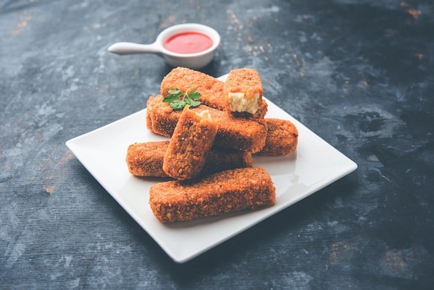 Dedos de Kurkuri paneer ou pakora, petiscos de pakoda também conhecidos como Barras de Queijo Cottage Crocante, servidos com ketchup de tomate como entrada. foco seletivo