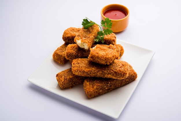 Dedos de Kurkuri paneer ou pakora, petiscos de pakoda também conhecidos como Barras de Queijo Cottage Crocante, servidos com ketchup de tomate como entrada. foco seletivo