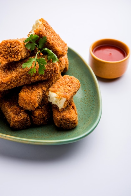 Dedos de Kurkuri paneer ou pakora, petiscos de pakoda também conhecidos como Barras de Queijo Cottage Crocante, servidos com ketchup de tomate como entrada. foco seletivo