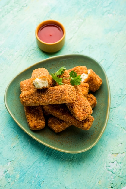 Dedos de Kurkuri paneer ou pakora, petiscos de pakoda também conhecidos como Barras de Queijo Cottage Crocante, servidos com ketchup de tomate como entrada. foco seletivo