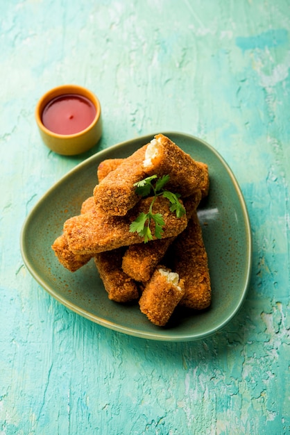 Dedos de Kurkuri paneer ou pakora, petiscos de pakoda também conhecidos como Barras de Queijo Cottage Crocante, servidos com ketchup de tomate como entrada. foco seletivo