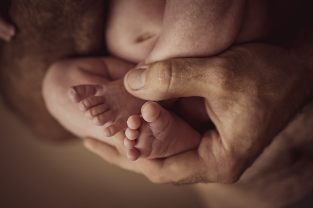 Dedos de perninhas de bebê nas mãos