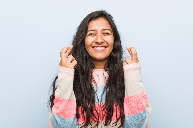 Dedos indianos do cruzamento da mulher nova da forma para ter a sorte