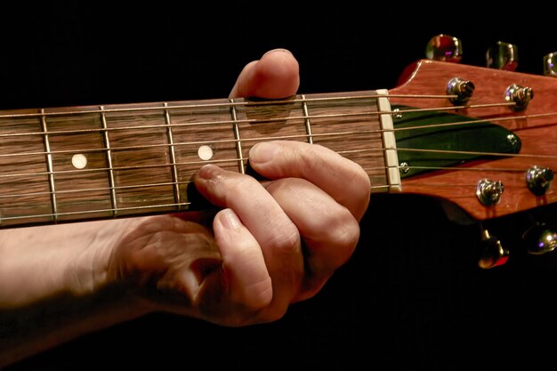 Foto dedos de los músicos tocando un acorde en el cuello de una guitarra