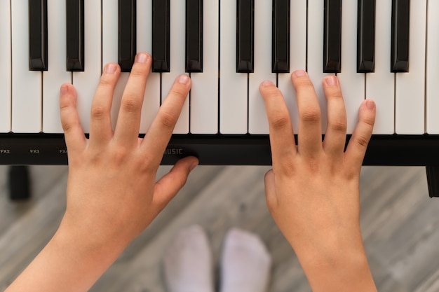 Los dedos del niño tocando el piano