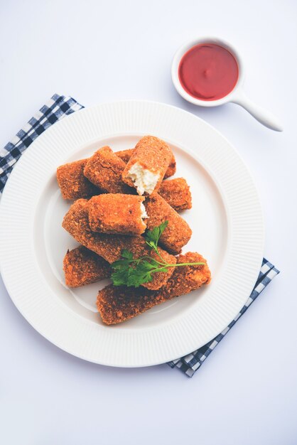 Dedos de paneer Kurkuri o pakora, bocadillos de pakoda también conocidos como barras de queso cottage crujientes, servidos con salsa de tomate como entrante. enfoque selectivo