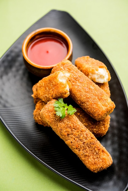 Dedos de paneer Kurkuri o pakora, bocadillos de pakoda también conocidos como barras de queso cottage crujientes, servidos con salsa de tomate como entrante. enfoque selectivo