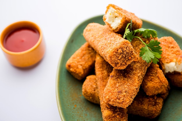 Dedos de paneer Kurkuri o pakora, bocadillos de pakoda también conocidos como barras de queso cottage crujientes, servidos con salsa de tomate como entrante. enfoque selectivo