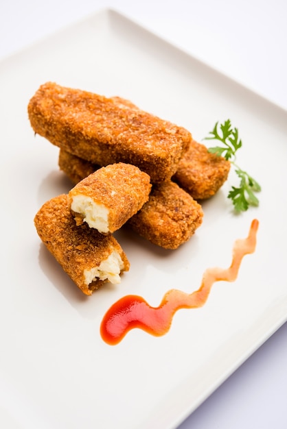 Dedos de paneer Kurkuri o pakora, bocadillos de pakoda también conocidos como barras de queso cottage crujientes, servidos con salsa de tomate como entrante. enfoque selectivo