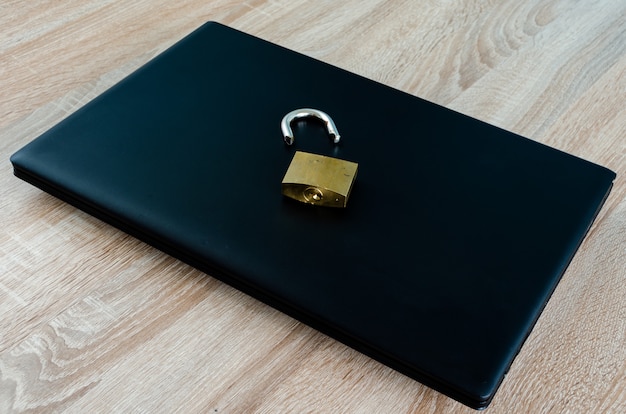 Defektes Vorhängeschloss auf geschlossenem Laptop, Konzept für Sicherheitsverletzung im Internet und Technologie oder Datendiebstahl