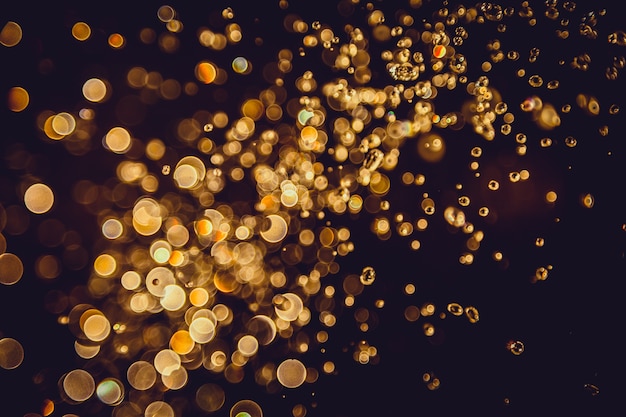 Defocus-bokeh Funkelngoldweinlese beleuchtet dunklen Hintergrund