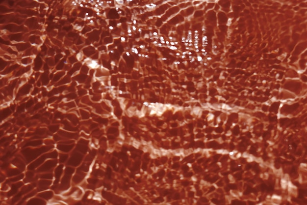 Defocus turva transparente cor de laranja clara textura de superfície de água calma com salpicos e bolha Fundo de natureza abstrata na moda Onda de água à luz do sol com espaço de cópia Cor de gota de água laranja