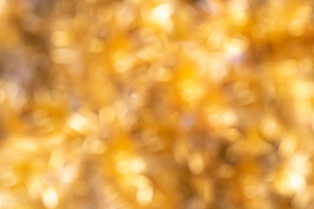 Defocused goldener Weihnachtsbokeh-Hintergrund. Goldfeiertag glühendes abstraktes Funkeln