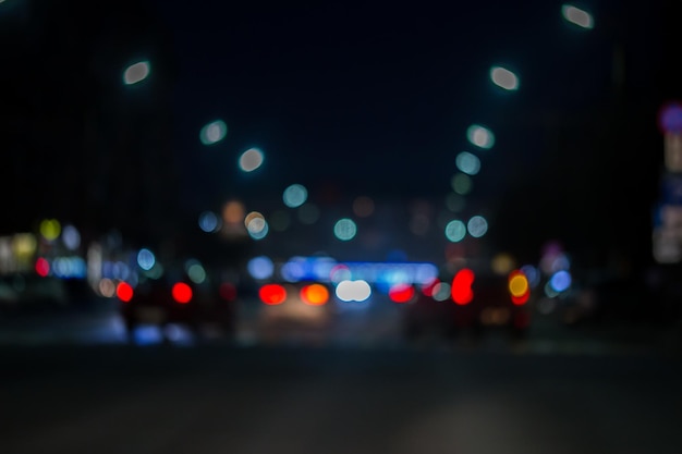 Defokussierter Blick aus dem Autofenster mit verschwommener Beleuchtung des Stadtverkehrs auf den Straßen der Stadt bei Nacht unscharfer Hintergrund