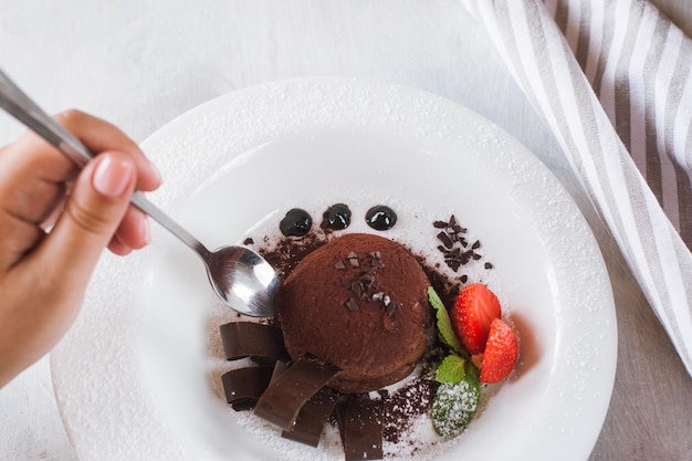 Degustación de deliciosos postres de chocolate en el restaurante Fondant en plato blanco con decoración de fresa y menta para gourmet real