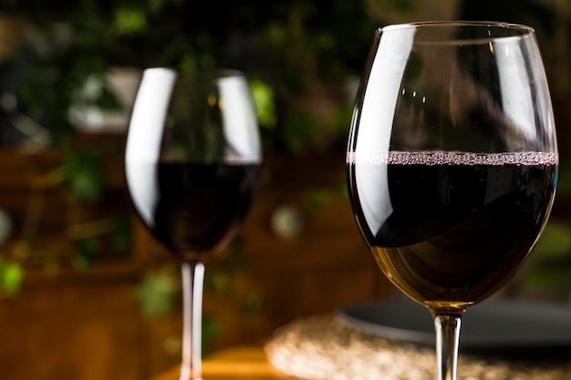 Degustación de vinos Una copa de vino tinto en el fondo de una mesa de restaurante con una botella en una cena o fiesta de eventos Foto de alta calidad